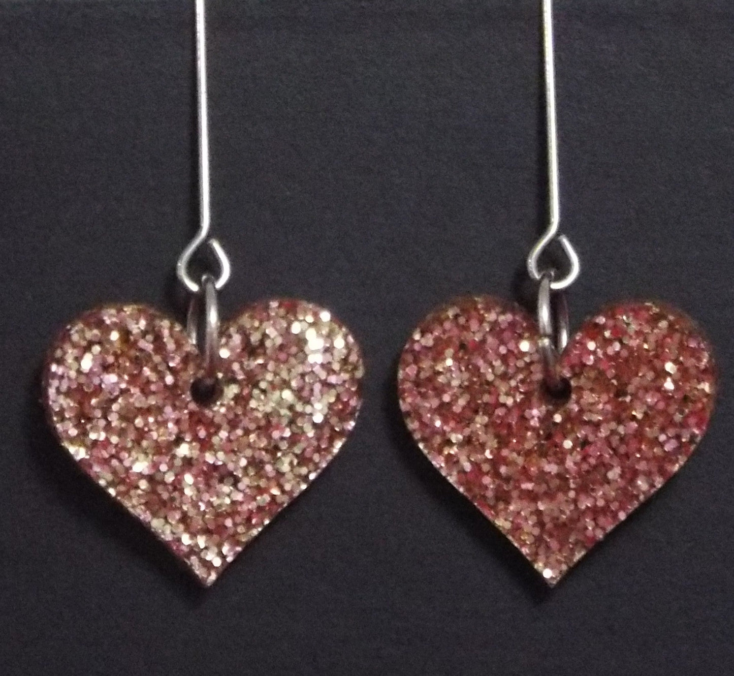 Pink heart dangle earrings with chunky glitter and heart cutouts, perfect for Valentine's Day.