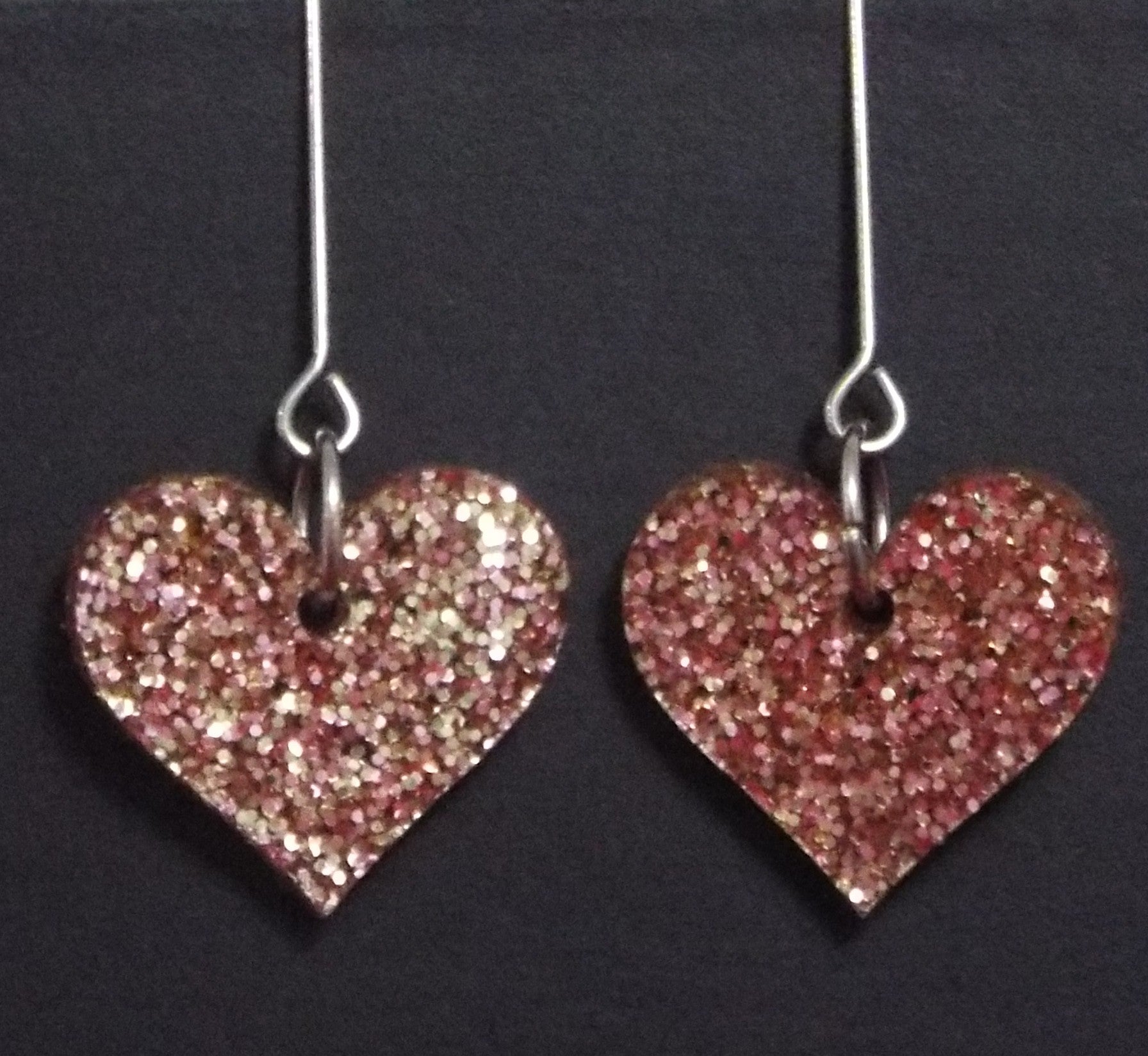 Pink heart dangle earrings with chunky glitter and heart cutouts, perfect for Valentine's Day.